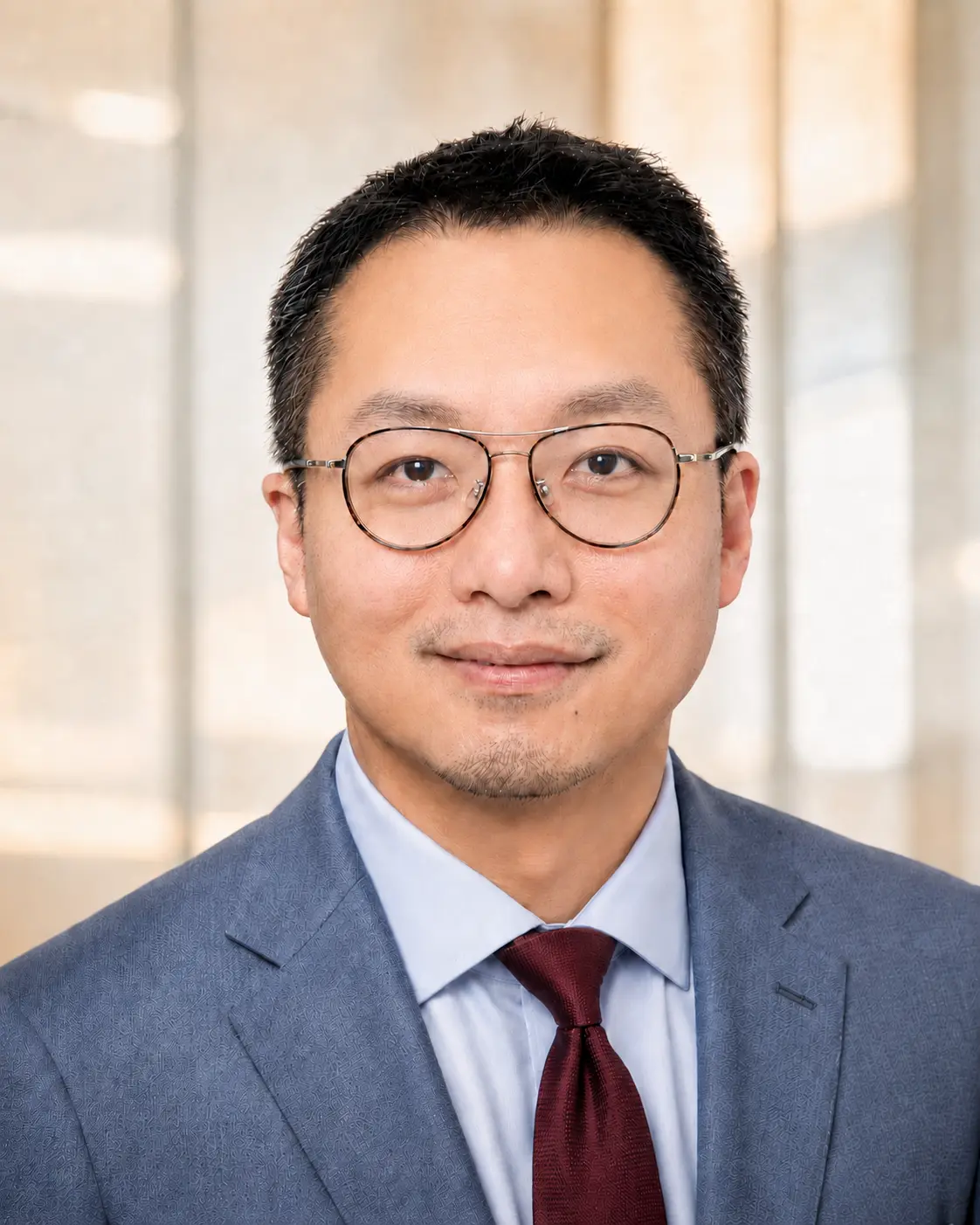 Joey Tsai in a blue suit, light blue shirt and burgundy tie